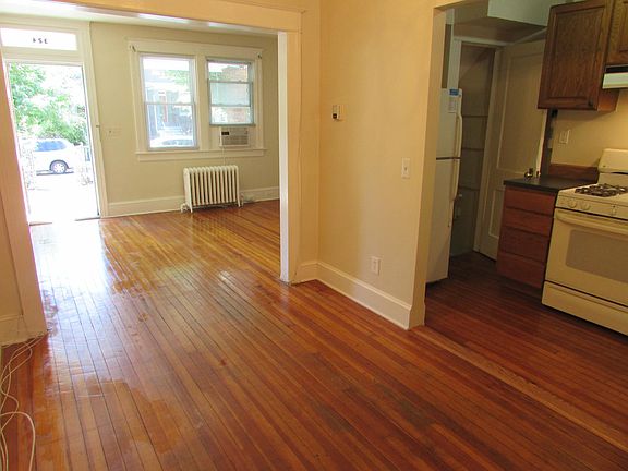 View of front door and living room from dining room and kitchen