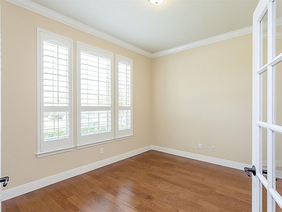 This spacious study is located off of the main entry and boasts French doors, handsome flooring, crown molding and plantation shutters.