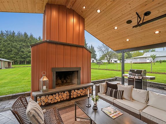 Wood burning fireplace with reclaimed copper roofing with thick slate mantle, heart & shoulders. Tongue and grove ceiling is breathtaking! This space is ready for dining or lounging on the stamped concrete patio. 
