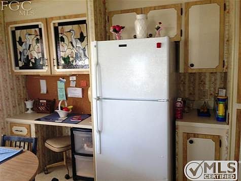 Full size fridge and pantry to right with desk to the left