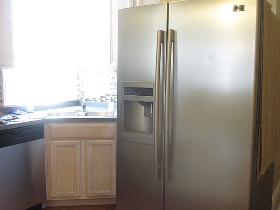 spacious kitchen with stainless appliances and window lighti