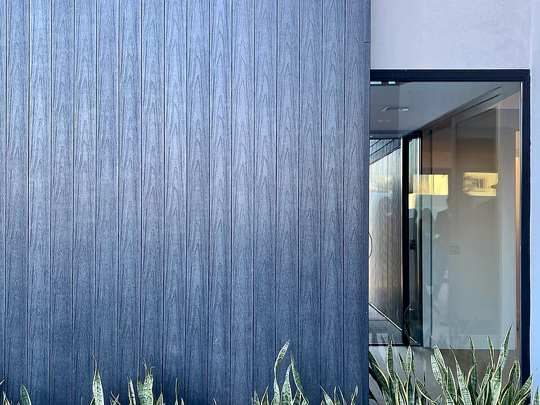 Layered modern materials, filtered light, and drought-tolerant planting reinforce the home's calm, low-maintenance lock-and-leave lifestyle.