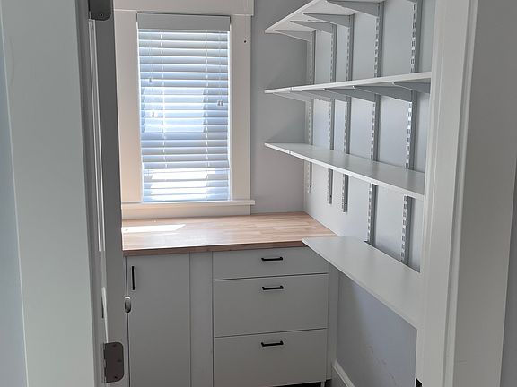 Walk in pantry off kitchen with built in storage, adjustable shelves, wall storage