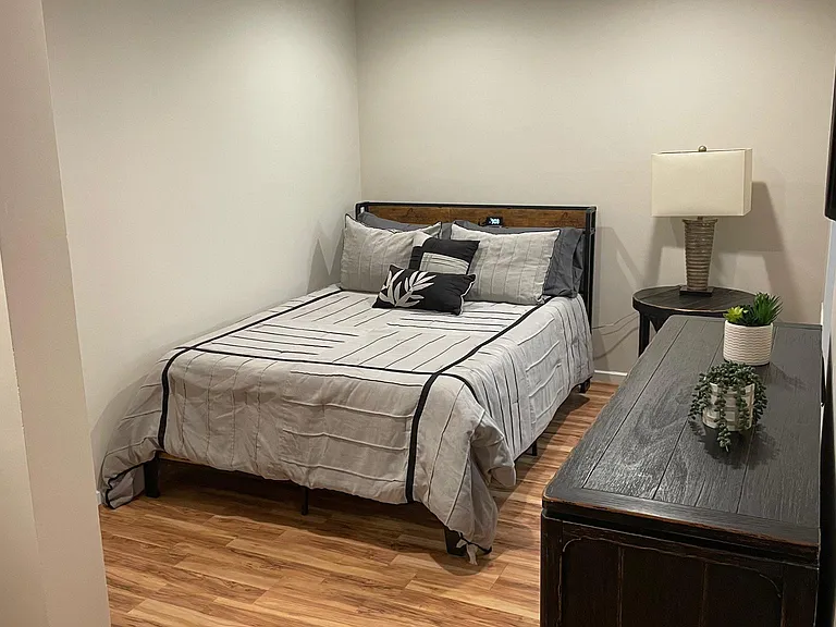Cozy bedroom with full size bed, nightstand, and dresser