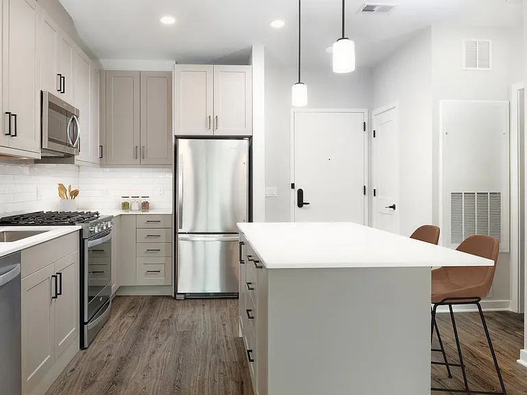 Upgrade Collection kitchen with stainless steel appliances, quartz countertops, tile backsplash, grey cabinetry, and hard-surface flooring