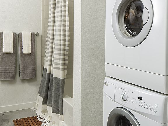 Apartment Bathroom with soaking tub and in-home washer and dryer.
