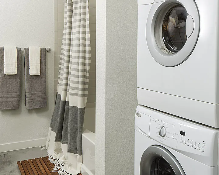 Apartment Bathroom with soaking tub and in-home washer and dryer.