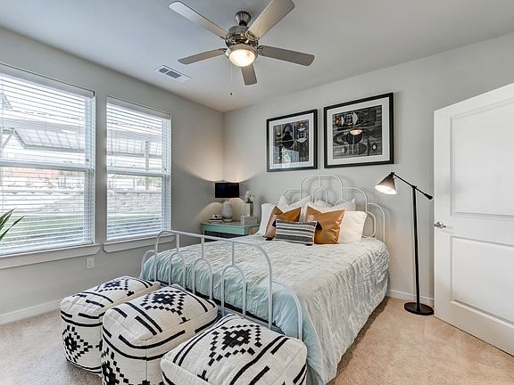 Primary bedroom with plush carpet and ceiling fan