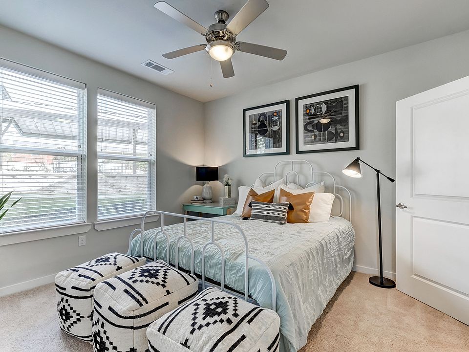 Primary bedroom with plush carpet and ceiling fan