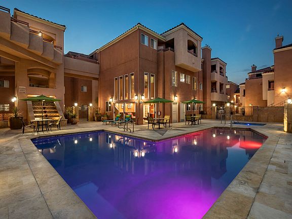 View of Lit Up Pool and Patio Tables