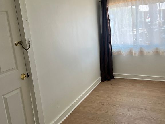 Living room with wood floor covering shows the closet door.