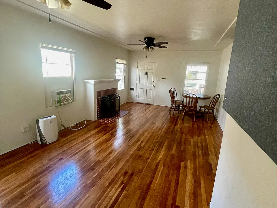 Living Room with Dual Ceiling Fans, Window A/C, and Decorative Fireplace