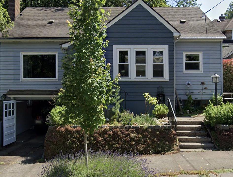 street view; garage on left, front door behind tree.