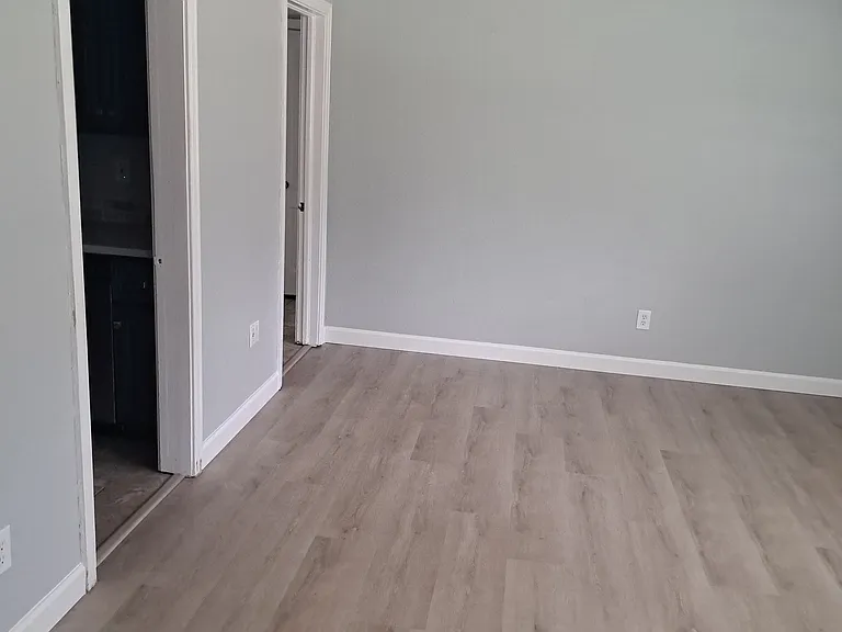 2nd living room with 4 large windows and kitchen on left