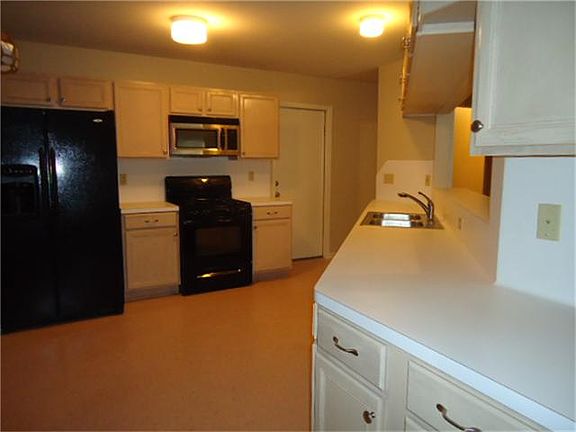 Open kitchen with newer appliances, gas range and stainless steel microwave