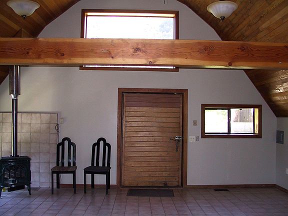 Unusual vintage freezer door for entrance with wood stove to left.