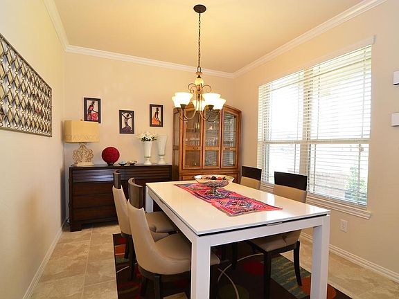 Wine and dine your guests in the formal dining room featuring crown molding, decorative lighting and tile flooring!