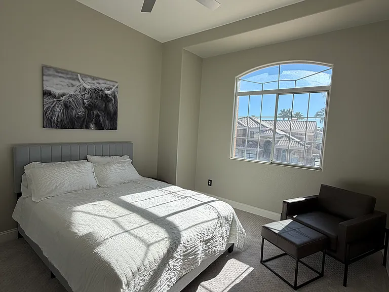 Generously sized bedroom with ceiling fan, closet and large window for natural light
