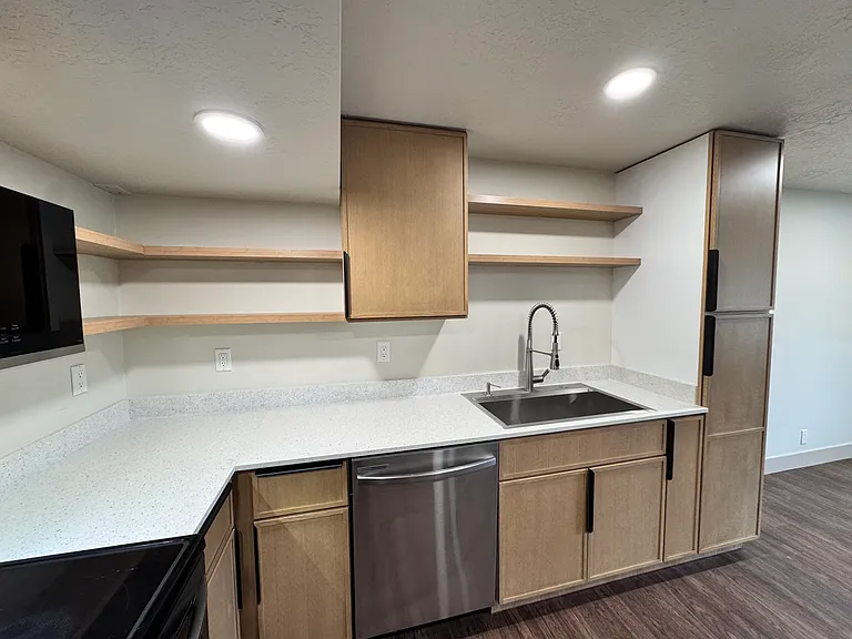 Bright kitchen with modern cabinetry, open shelves, and generous countertop space_ideal for everyday use.