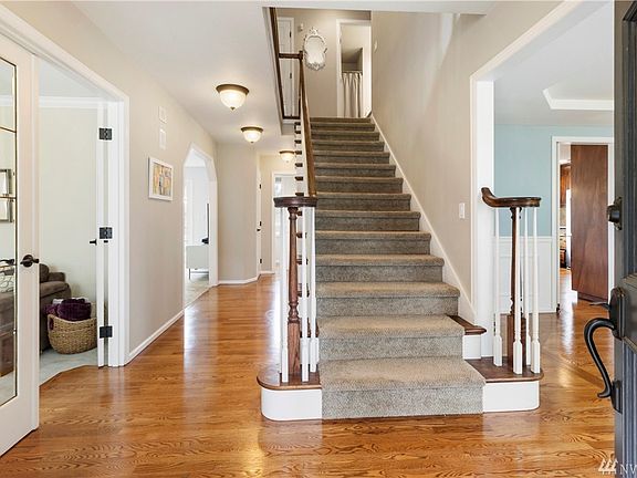The home features an open entry, security system, built-in vacuum, skylights, beautiful hardwood flooring, an open banister staircase, white trim work and more!