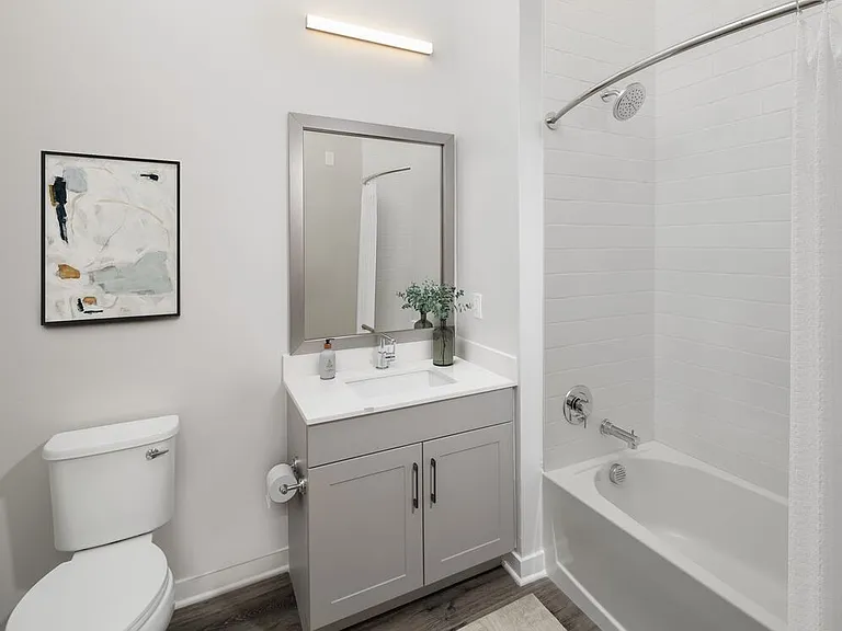 Upgrade Collection II bath with white quartz countertop, grey cabinetry, and hard surface flooring
