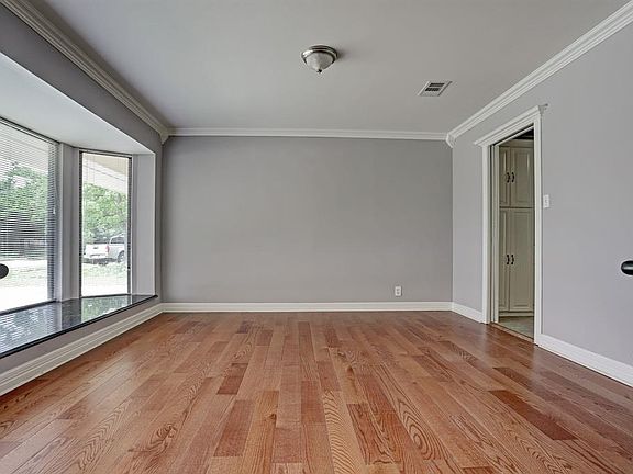 Large dining room with architectural accents and molding and huge feature window opens from the hallway.