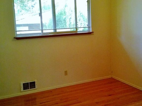This image shows the bedroom. The walls are actually white (not the greenish hue seen here) and the floor is not quite so shiny. The room is a fully functioning bedroom, but does not have a door - hence the studio classification. The divider wall allow
