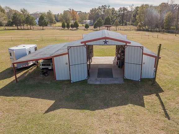 36 X 36 large metal building with overhang for parking or storage. Reinforced slab for trailer or RV parking. Metal building is on it's own electric pole. Could be built out for barndominium.