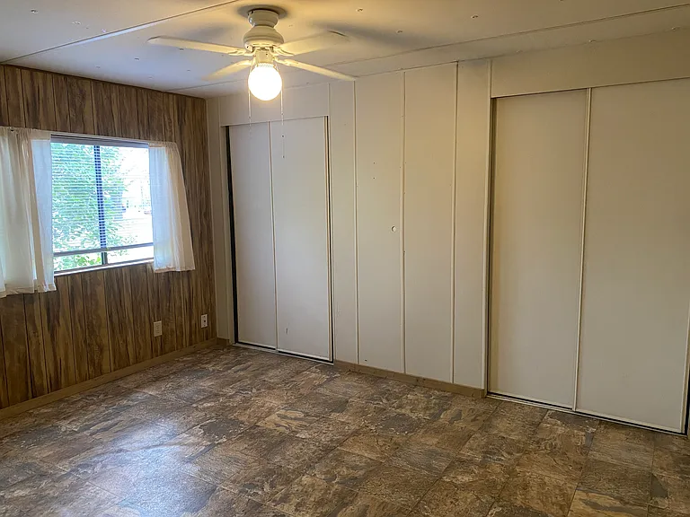 First bedroom has two large windows that look out into the front yard.