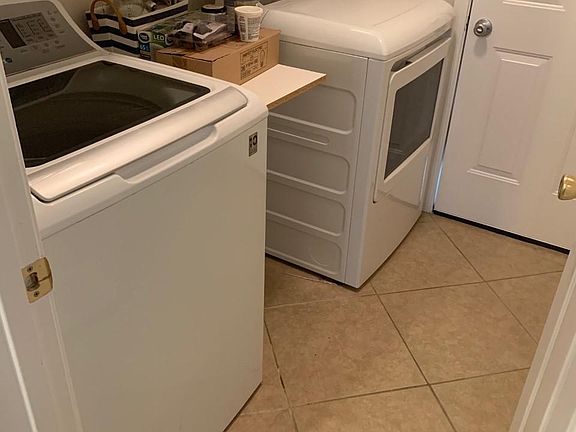 Laundry room with washer dryer included; storage above