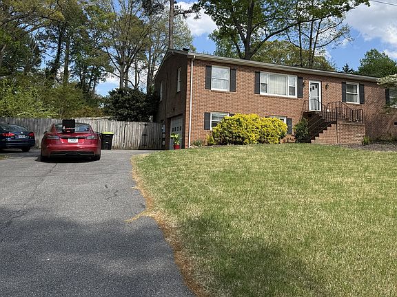 front with large driveway extra parking on left side and attached garage