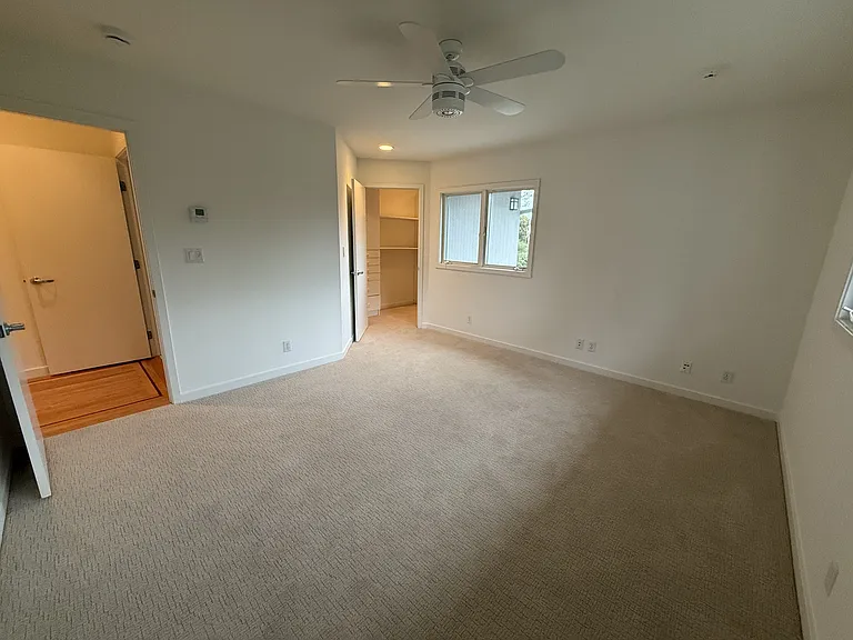 Second bedroom has ceiling fan, spacious walk-in closet and comfortable plush carpet.
