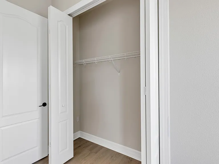 Bedroom closet with doors open. This is a tall closet. This room also has attic access that is insulated and temperature controlled for additional storage.