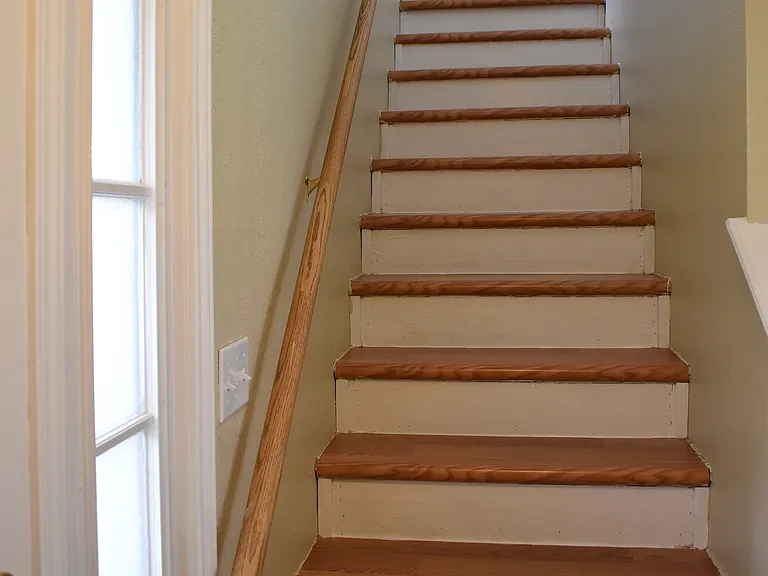 Stair near the front door leads to the three bedrooms and the two bathrooms upstairs