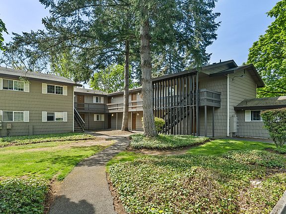 Picturesque view of a two-story apartment building surrounded by lush greenery.