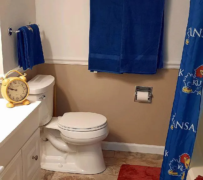 ...the bathroom has tile floors and a vanity cabinet with a large mirror above and drawers for storage...