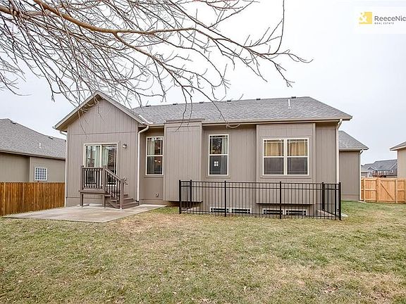 Back of house, iron fence to keep littles and fur babies out of window well.