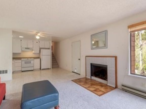 Flowing open floor plan with living room, kitchen, and enclosed patio/sunroom.