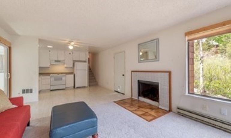 Flowing open floor plan with living room, kitchen, and enclosed patio/sunroom.