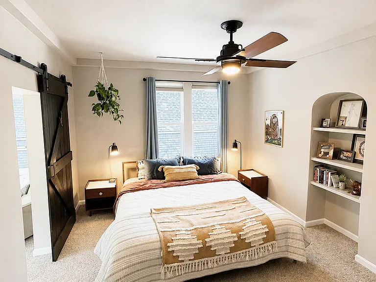 2nd primary bedroom on upper level with adjoining full bathroom, custom large walk-in closet, ceiling fan, built-in bookcase, and sunroom.