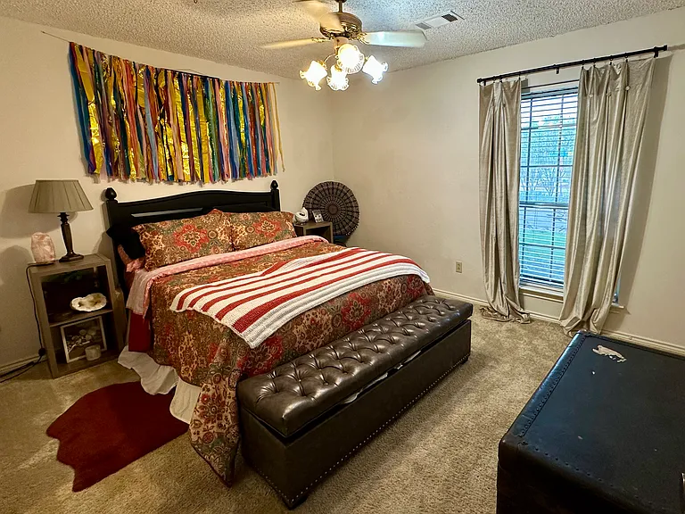 Bedroom with carpeted floors, a ceiling fan