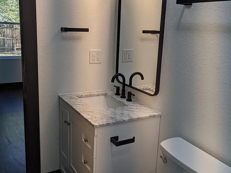 sink and toilet taken from the bathtub side in master bedroom.