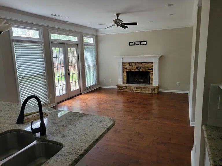 From the Kitchen into the main area for sofas and living. The window/doors open to the back yard.
