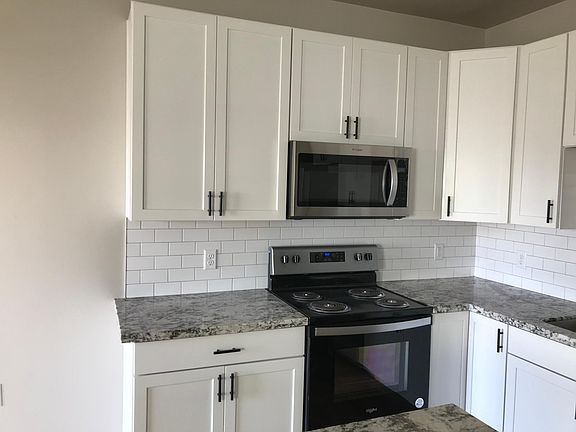 Kitchen with nice white cabinets and stainless steel appliances.