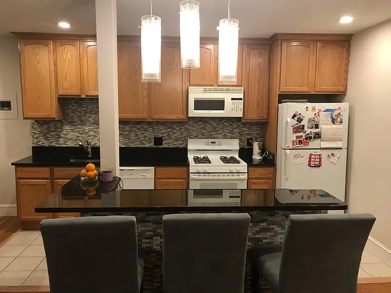 Open floor plan- furnished kitchen with cookware and silverware, furnished island with bar stools
