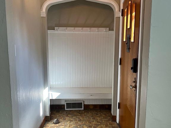 Foyer with coat hangers and space for storage baskets under the bench