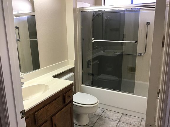 Guest bath with gray glass tub enclosure.