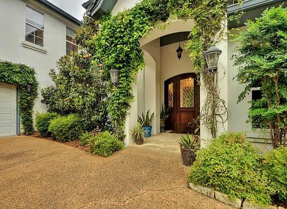 Lush landscaping adorns the exterior of the home and creates a welcoming front entry.