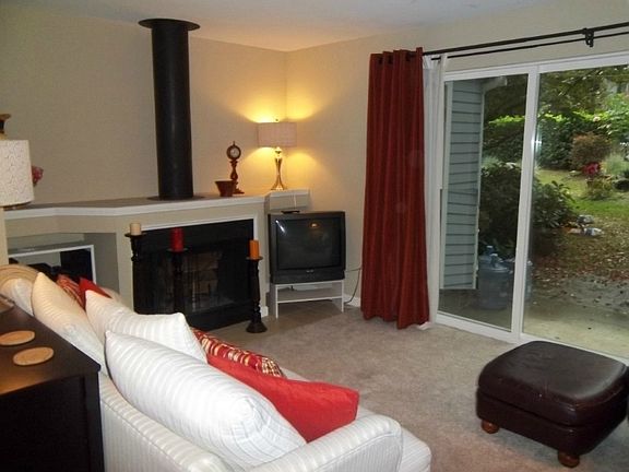 Living room has wood burning fireplace & sliders to patio.