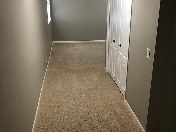 Hallway to Lower Level living area and bedroom. Laundry to the right (behind closet doors)